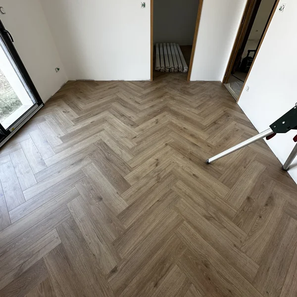 Parquet en chevrons ton grisé dans une pièce claire