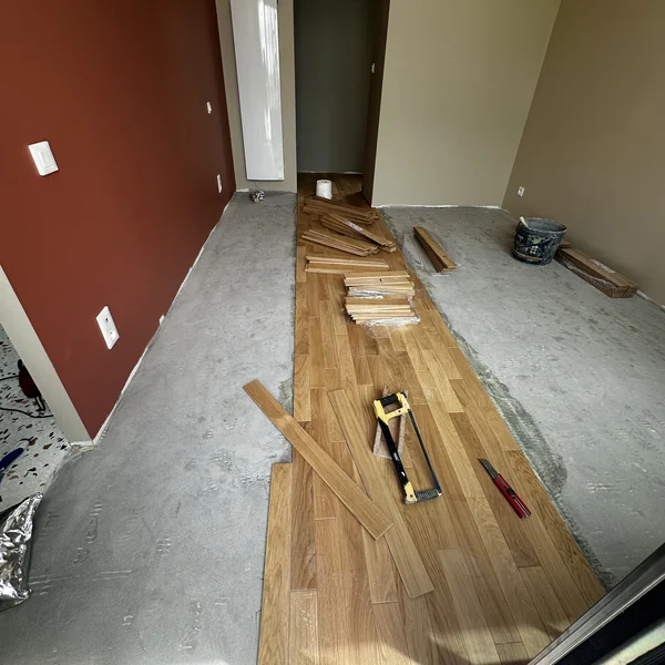 Chantier de pose de parquet chêne en cours, avec outils