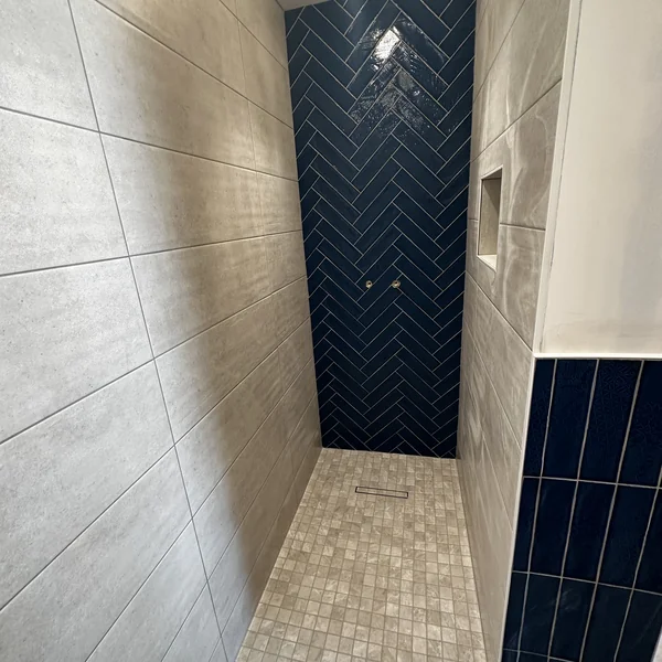 Salle de bain avec carrelage métro gris et faïence bleue en chevrons