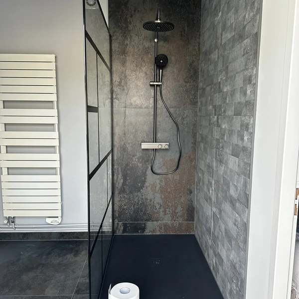 Douche italienne avec mur grand format effet métal oxydé et verrière noire